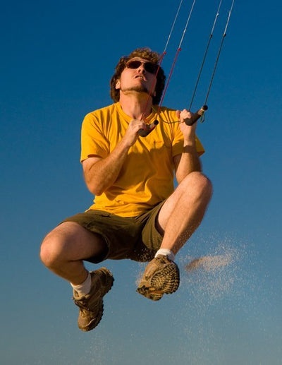 Man jumps in the air as he flies a Tensor power kite