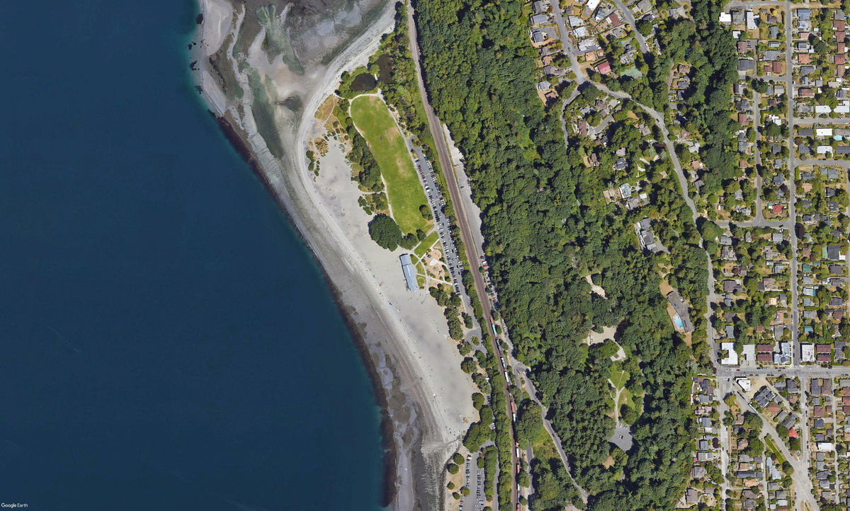 Beach bordered by water to the west and trees to the east