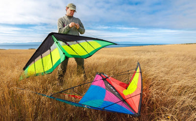 Mark adjusting bridles on a kite in an open field