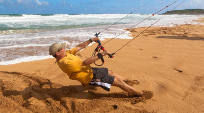Man being pulled along beach by power kite